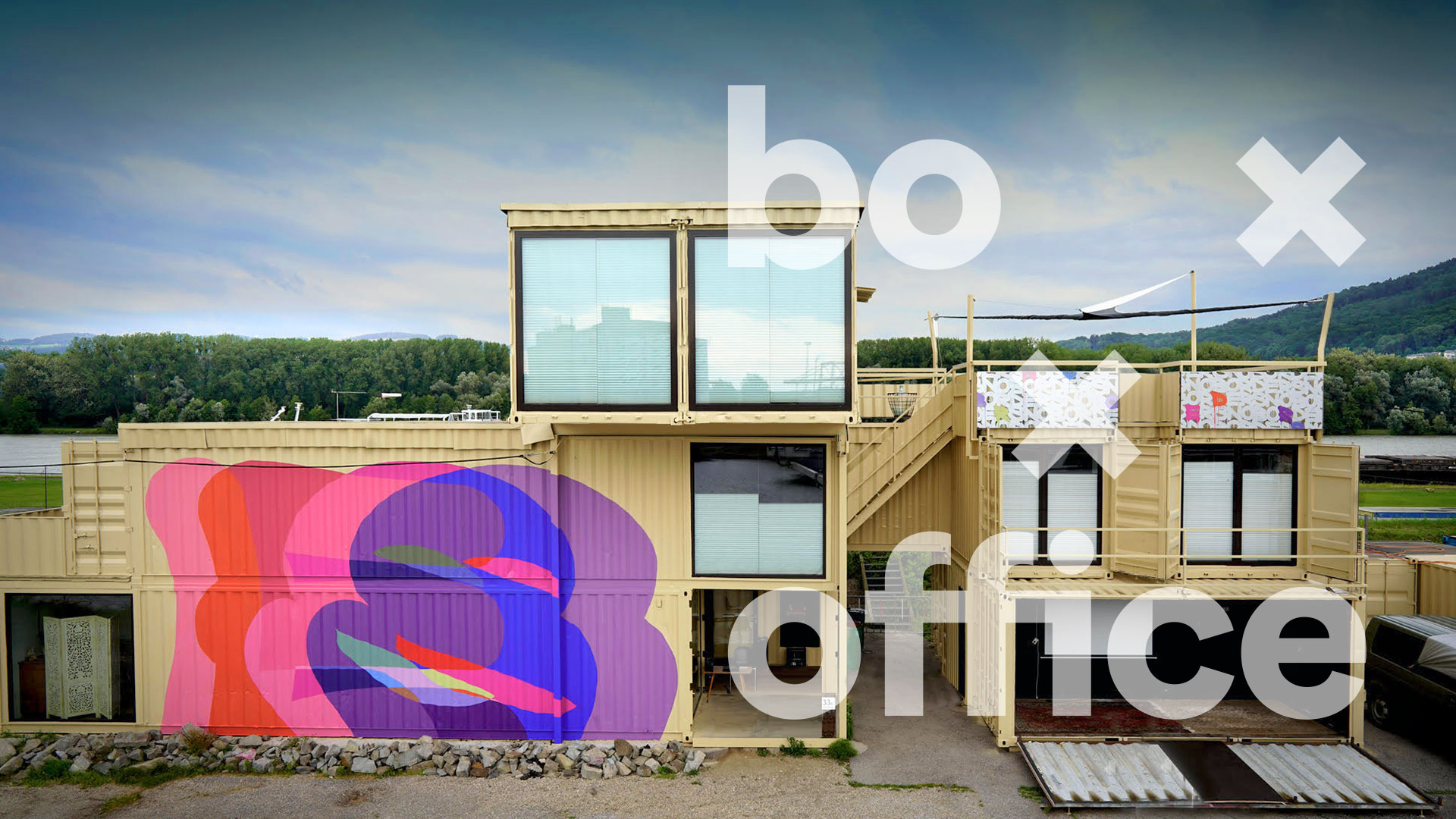 BoxxOffice-Gebäude aus Containern im Linzer Hafen mit buntem Wandbild und dem Schriftzug boxx office