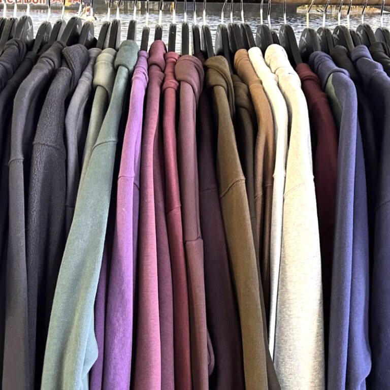 Sweatshirts und Pullover in vielen Farben auf einer Kleiderstange