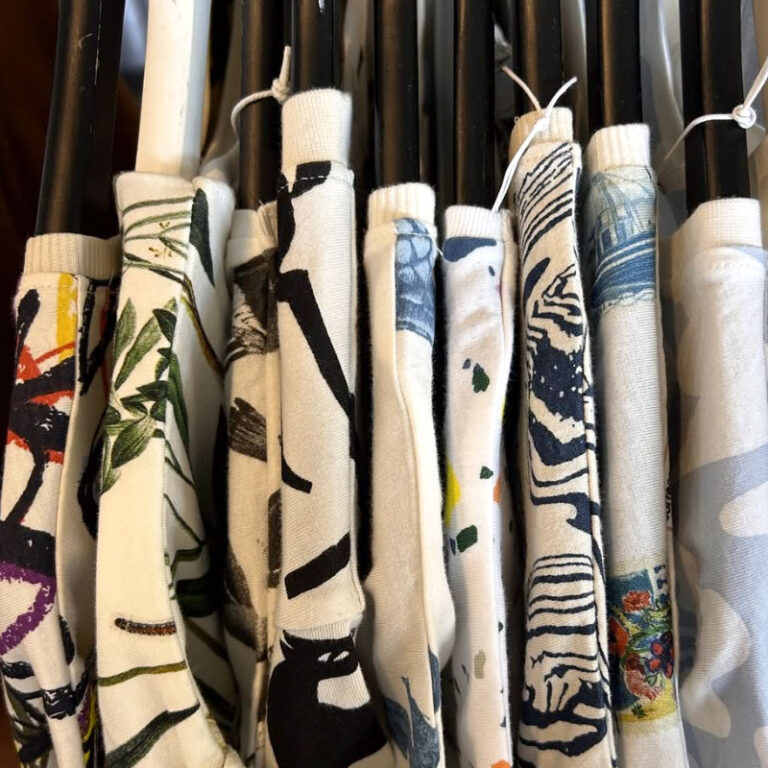 Weiße Sweatshirts mit grafischen Prints auf einer Kleiderstange